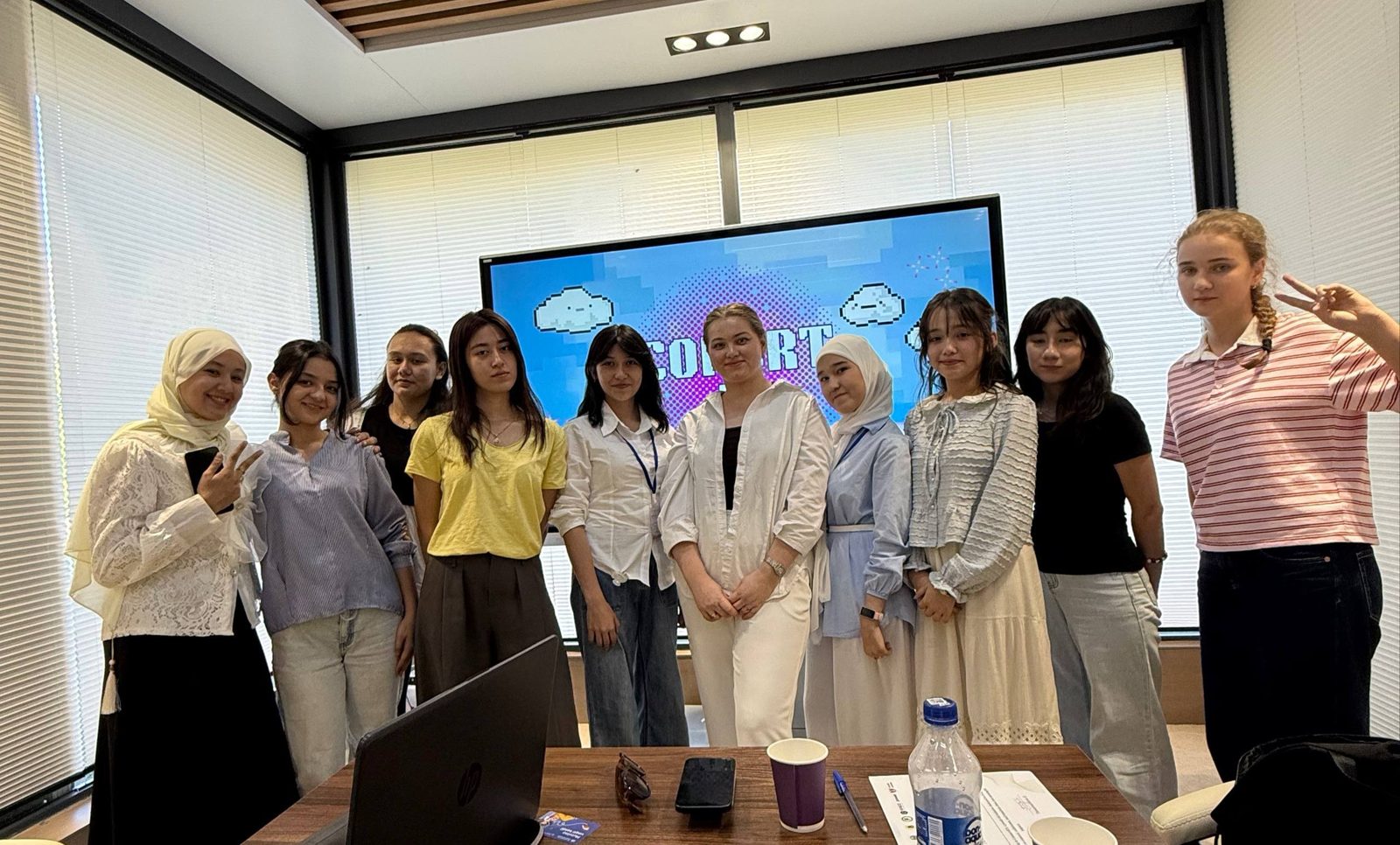 A group of Cohort 4 participants posing in front of the Cohort 4 screen